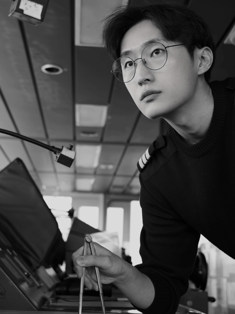 Lee Hyeonchang aboard a container ship, working at the chart table